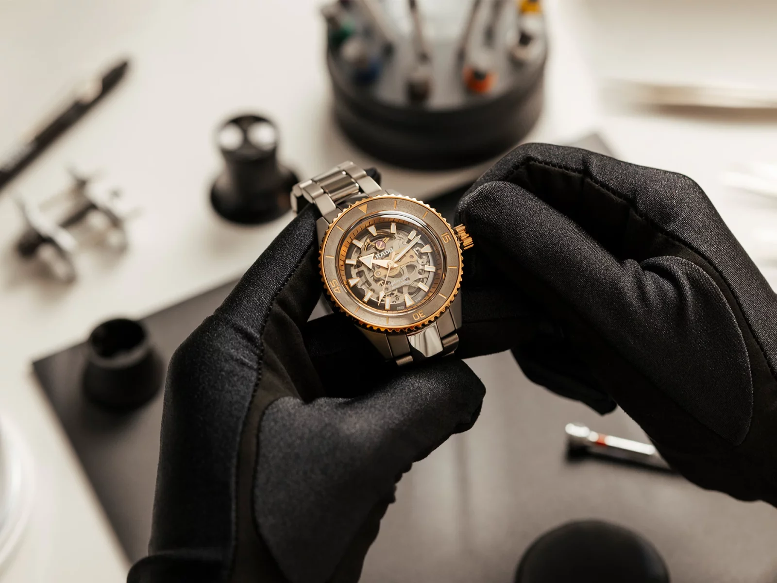 Een horloge wordt met handschoenen nagekeken in het atelier