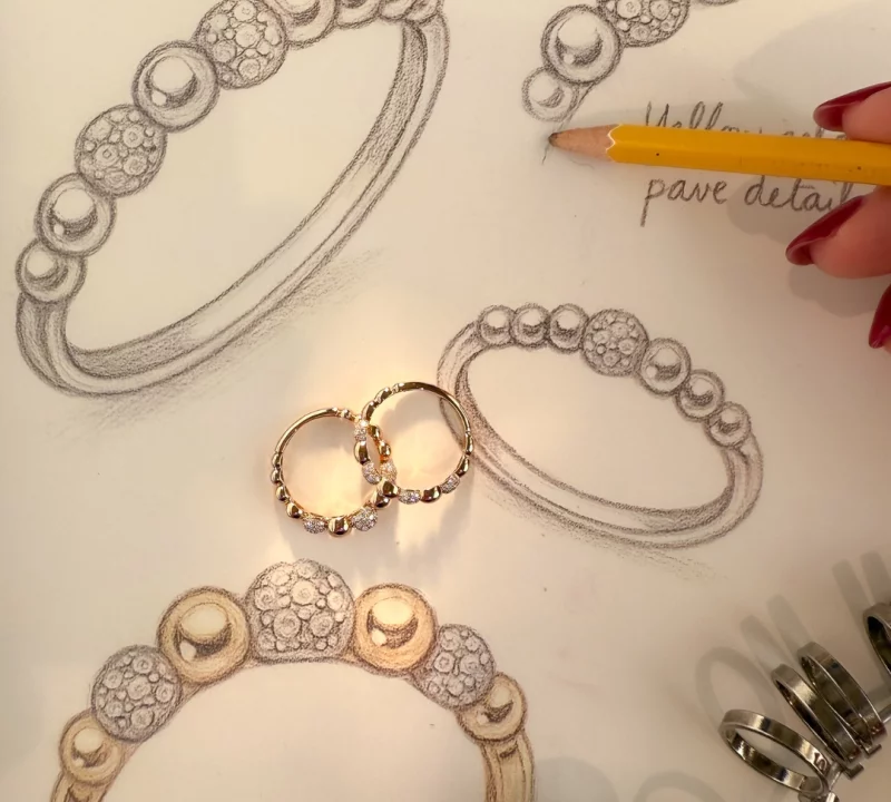 Ontwerpschets van gouden ringen met diamanten, naast de afgewerkte ringen