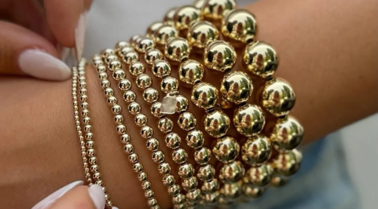 Gouden armbanden om een pols